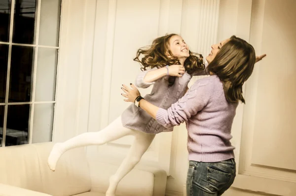 Menina pulando em suas mãos mãe — Fotografia de Stock