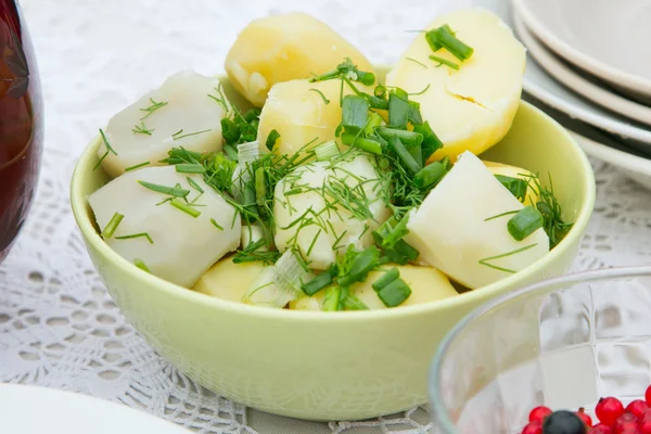 Potatoes cooked in a round dish. Chopped fresh herbs. — Stock Photo, Image