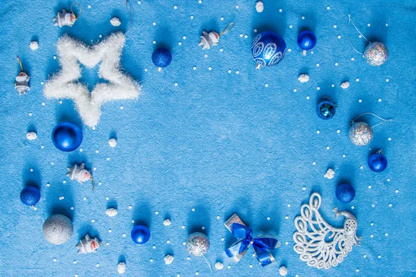 在柔软的蓝色背景 银色和蓝色的圣诞玩具和一个白色蓬松的明星 复制空间 — 图库照片