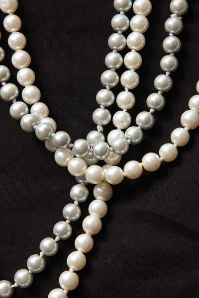 Fili di perle bianche su sfondo nero — Foto Stock