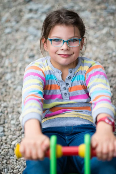 Funny girl in eyeglasses playing at playground — Stock Photo, Image