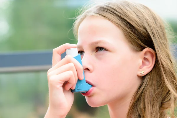 Chica con asma usando el inhalador de asma — Foto de Stock