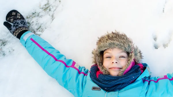 Gelukkig kind meisje vaststelling op een bevroren duidelijk sneeuw — Stockfoto