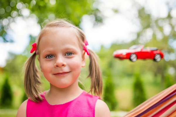 Mała dziewczynka uśmiechając się i marzy o nowy samochód — Zdjęcie stockowe