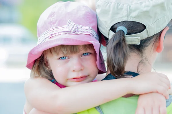 Сумний плаче маленька дівчинка обіймає матір — стокове фото