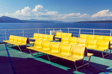 Hırvatistan 'daki Adriyatik feribotunun üst güvertesinde boş sarı sandalyeler - banklar -