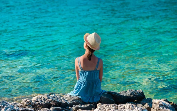 Menina Chapéu Palha Vestido Verão Azul Sentado Uma Costa Marítima — Fotografia de Stock