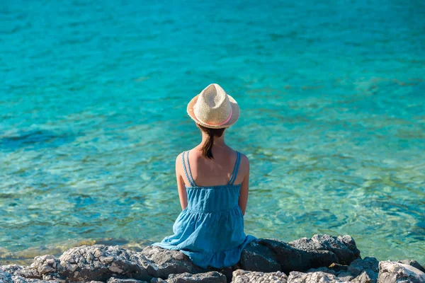Menina Vestido Verão Azul Chapéu Palha Sentado Uma Costa Rochosa — Fotografia de Stock