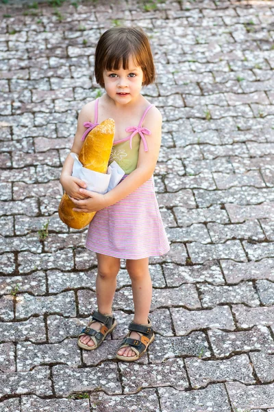 Little girl holding a loaf of bread — Stock Photo, Image