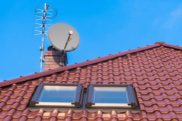 Janelas de telhado, chaminé e antenas — Fotografia de Stock