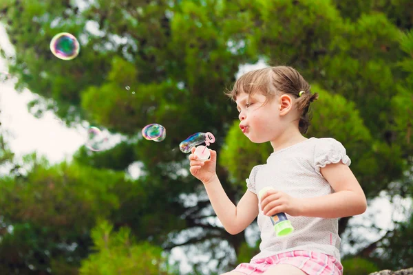 Söt liten flicka blåser såpbubblor — Stockfoto