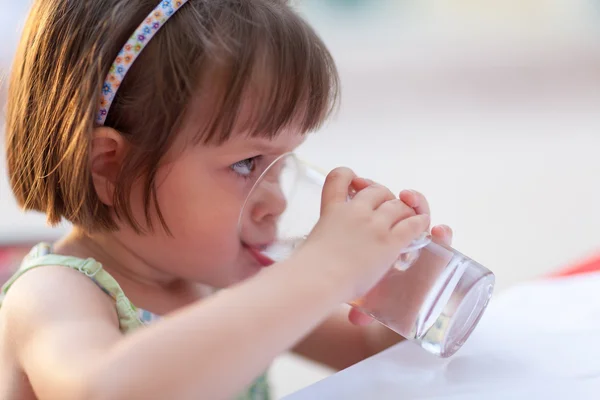 Little girl drinking water outdoors — Stock Photo, Image
