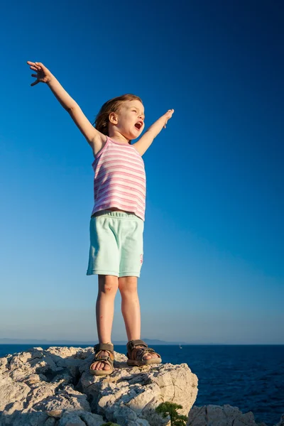 Ευτυχισμένος κορίτσι στο βράχο με τα χέρια ψηλά — Φωτογραφία Αρχείου
