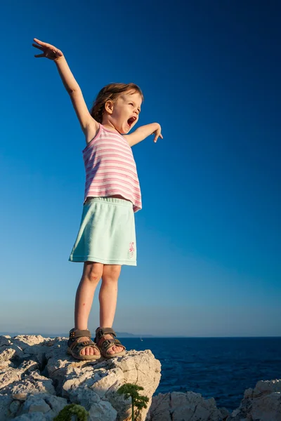 Menina feliz na rocha com as mãos para cima — Fotografia de Stock