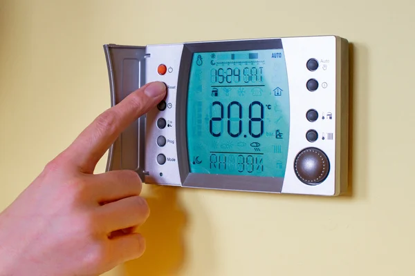 Closeup of a woman's hand setting the room temperature on a mode — Stock Photo, Image