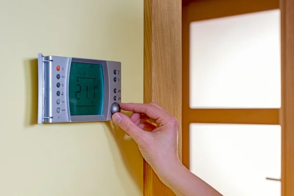 Closeup of a woman's hand setting the room temperature on a mode — Stock Photo, Image