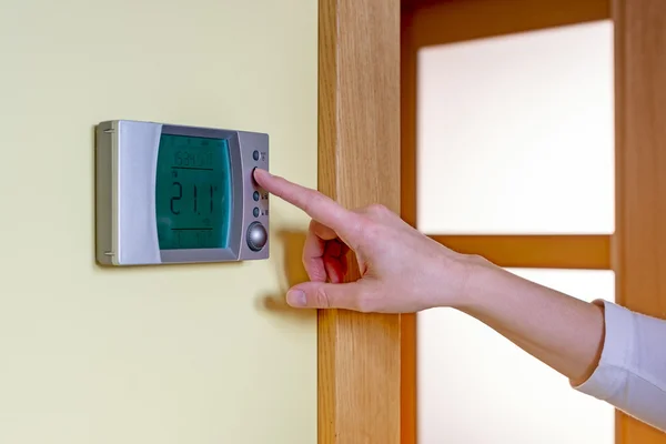 Closeup of a woman's hand setting the room temperature on a mode — Stock Photo, Image