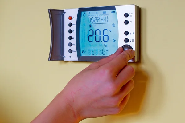 Крупный план руки женщины, устанавливающей комнатную температуру в режиме Лицензионные Стоковые Фото