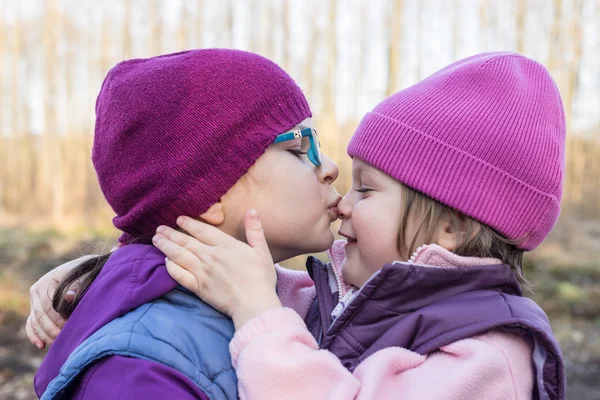 Sister lovingly kissing her younger sister — Stock Photo, Image