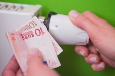 Radyatör termostat, banknot ve el - yeşil