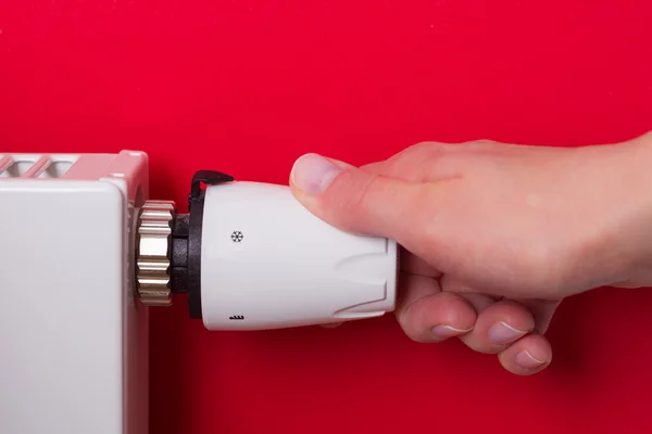 Radiator thermostat and hand - (red) — Stock Photo, Image