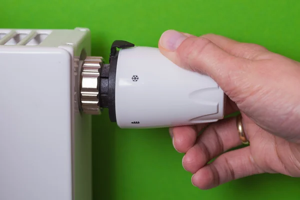 Radiator thermostat and hand - green — Stock Photo, Image