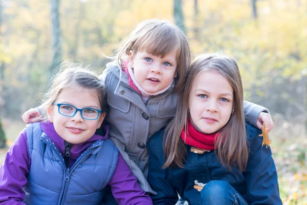 Three sisters in the autumnal forest smiling — Stock Photo, Image