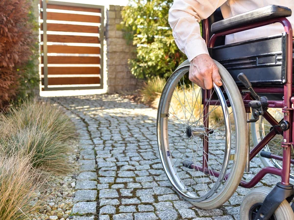 Крупный план мужской руки на колесе инвалидного кресла — стоковое фото