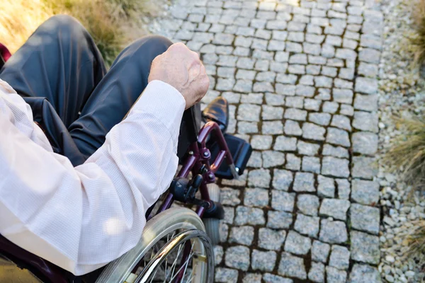 Крупный план мужской руки на колесе инвалидного кресла — стоковое фото