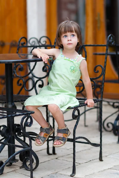 Серьезная маленькая девочка ждет за кофейным столиком — стоковое фото