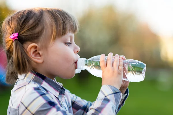 Портрет маленькой девочки, пьющей воду на открытом воздухе — стоковое фото