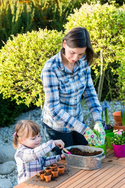 Fata plantarea bulbi de flori cu mama ei — Fotografie, imagine de stoc