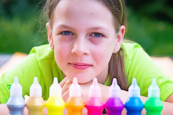 Чарівна молода дівчина з барвистими пляшками фарби перед h — стокове фото