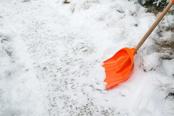 Hóeltakarítás. Narancs lapát a hó — Stock Fotó