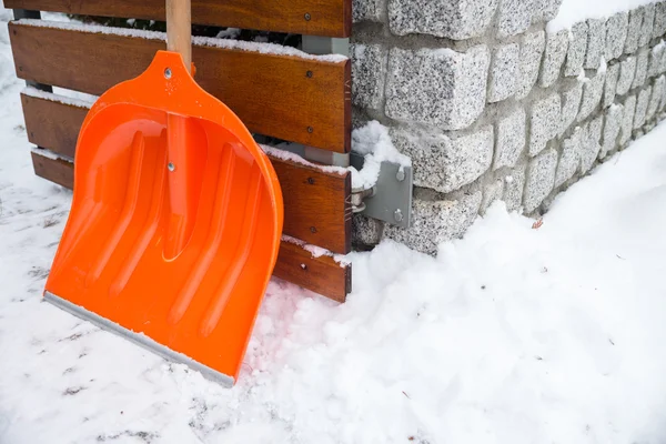 Snöröjning. Orange spade i snö — Stockfoto