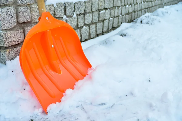 Snöröjning. Orange spade i snö — Stockfoto