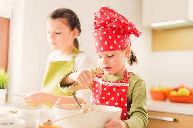 İki kız kardeş granola birlikte hazırlanıyor. 