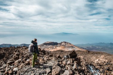 Tenerife 'deki El Teide yanardağının tepesindeki genç adam ya da vadiden aşağı bakan muhteşem manzaralı dağ. Pico Viejo volkanı derecesi