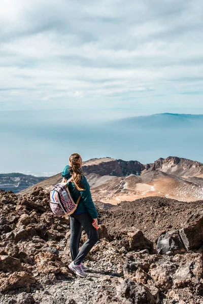 Junge Frau auf dem Gipfel des Vulkans El Teide auf Teneriffa oder in den Bergen, die das Tal hinunter blicken, mit herrlicher Aussicht. Rater des Vulkans Pico Viejo — Stockfoto