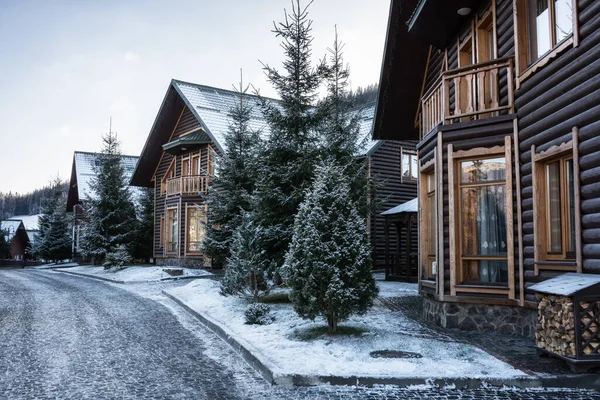 Snow-covered houses in the mountains. Cottages at a ski resort. Winter street. Winter Ukrainian Carpathians. — Stock Photo, Image