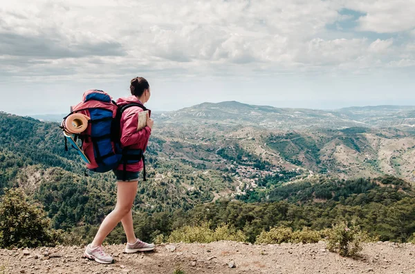 Young woman travel girl with backpack walks on beautiful landscape background, sea and hills, cape of Aphrodite, Cyprus, popular destination for summer vacation — Stock Photo, Image