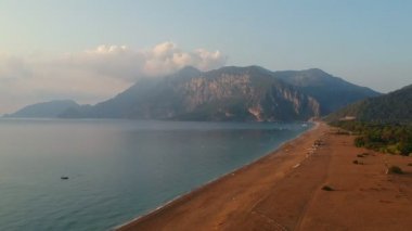 Cirali köyündeki kumsalda sabah, sarı kumsalda balık ağları uzanıyor. Taurus dağının yakınındaki gemiler ve gemiler kıyıya demirlemiştir. Lycian Patikasının Manzaraları.