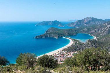 Türkiye 'nin güneybatısındaki Oludeniz, Fethiye, Turkuaz sahillerindeki mavi göl ve kumsal panoramik hava manzarası. Oludeniz 'de güneşli ve açık mavi gökyüzü.