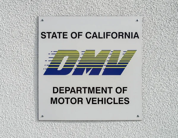 California Dmv Schild Mit Logo Auf Der Weißen Strukturierten Wand lizenzfreie Stockbilder