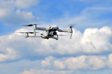 Dron kuadkopteri mavi gökyüzü arka planına sahip yakın plan görüntüsü ile uçuyor. Dijital kamerayla uçan İHA helikopter. Mavi gökyüzünde bir fotoğraf robotunun görüntüsü.