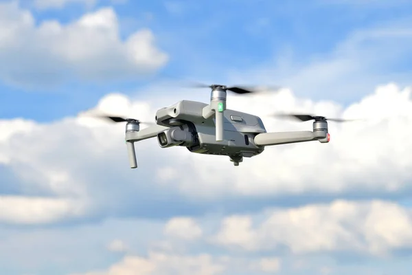 Uçan drone kuadkopteri mavi gökyüzü arka planına sahip yan görüntüsü yakın çekim. Dijital kamerayla uçan İHA helikopter. Mavi gökyüzünde bir fotoğraf robotunun görüntüsü.