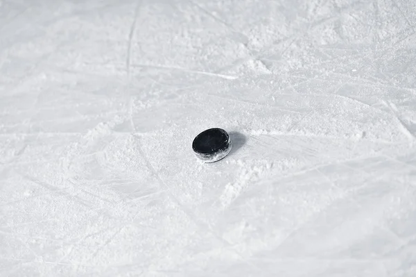 Hockey puck on the surface of ice rink — Stock Photo, Image