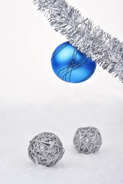 Silberne und blaue Weihnachtskugeln im Schnee lizenzfreie Stockfotos