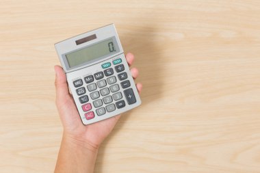 Elini tut hesap makinesi ahşap arka plan üzerinde