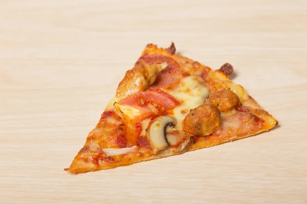 Afgesneden slice pizza op hout — Stockfoto